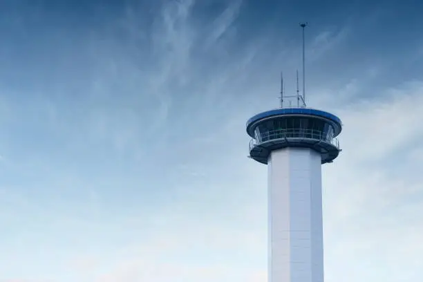 Communication tower high in blue sky with aerial for mobile technology network UK