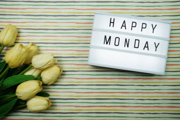 istock Top view Happy Monday Text in Light box flat lay with tulip flower bouquet 1197428261