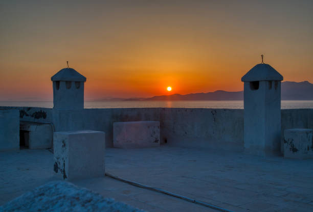 Sunset in Andros island, chimneys silhouette. Cyclades, Greece