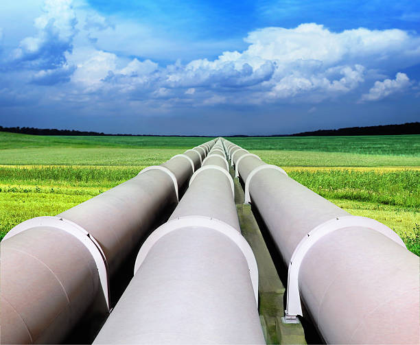 tres gasoductos en un campo verde y azul cielo - gas fotografías e imágenes de stock