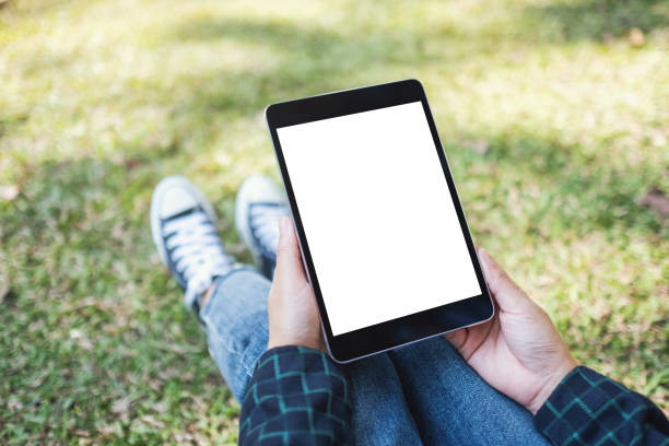 istock a woman holding and using black tablet pc with blank white desktop screen while sitting in the outdoors 1197443711