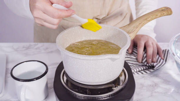 istock Caramelizing sugar in a small cooking pot over the small electric stove. 1197448768