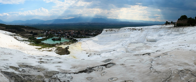 Natural travertine, terraces with pools with spring thermal water also called Cotton Castle. Wide panoramic view on sunset. Pamukkale, Turkey.
