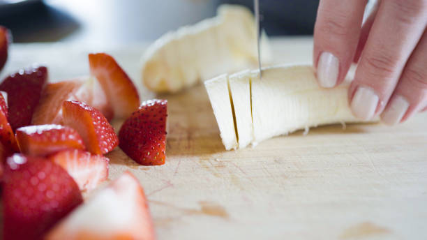 istock Slicing fresh banana on a wood cutting board. 1197452627