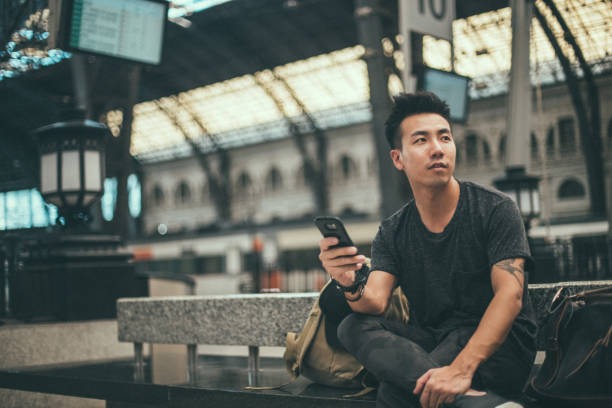 istock Hipster man on the railway station 1197453593