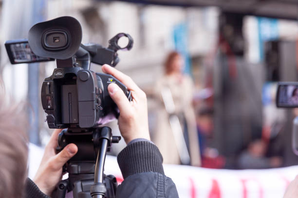 istock Camera operator recording female speaker at public protest 1197454867