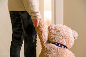 Little girl holding hand of teddy bear and going to her room. Loneliness, child in need of friendship. Sad kid holding hand with plush toy, best friends