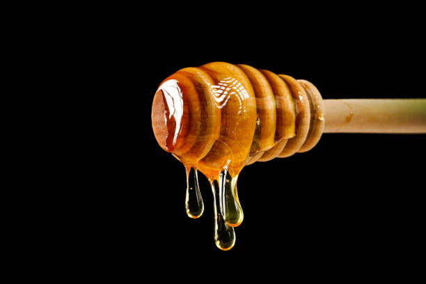 istock honey dripping from honey spoon 1197461928