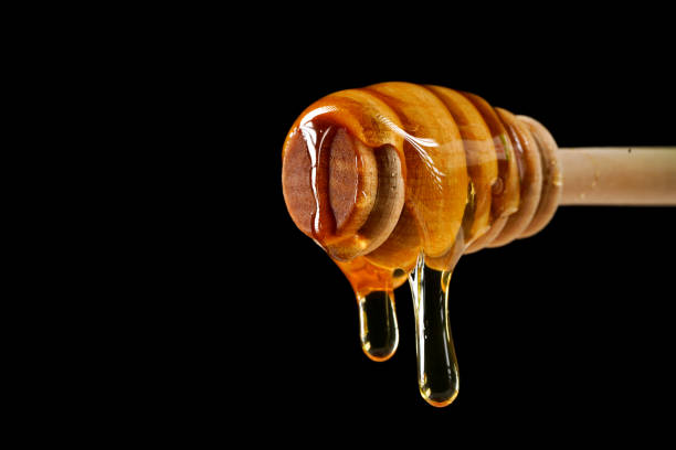istock honey dripping from honey spoon 1197462532