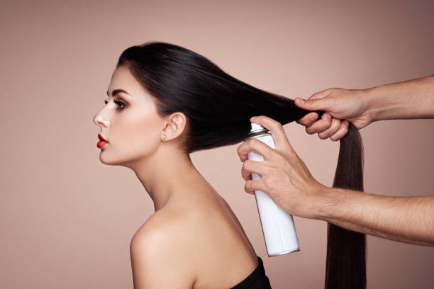 Hairdresser styling woman's hair stock photo