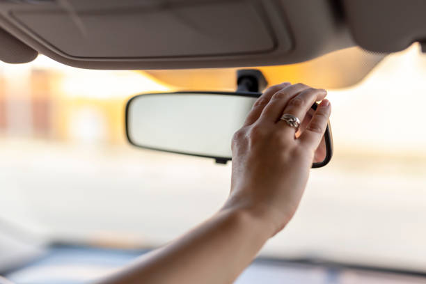 istock Woman adjusting rearview mirror in the car 1197468694