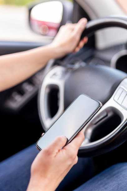 istock Woman using phone and driving a car 1197468804