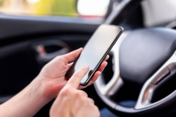 istock Woman sitting in a car and using smart phone 1197468823