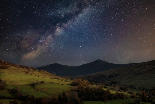 Beautiful epic digital composite landscape of Milky Way over Keswick in Lake District
