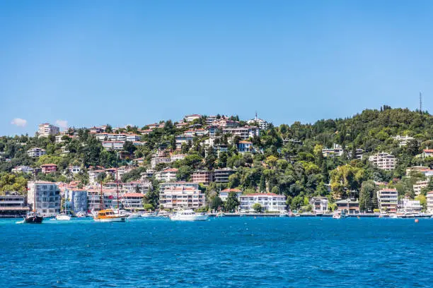 Beautiful builings and mansions at the costline and hillslope with green forest in summer, at Bosphorus Strait in Istanbul,Turkey. View from a Cruise Ship.