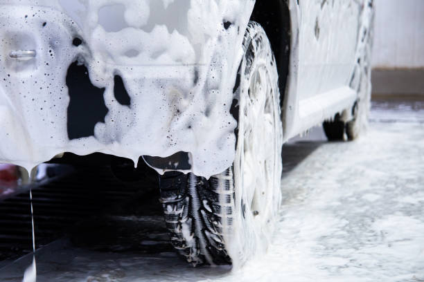 istock a car covered by soap foam while washing indoors - close-up low position view from back with selective focus 1197473432