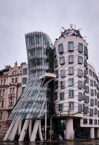 Famous dancing house (Ginger and Fred) in Prague, Czech Republic Prague, Czech Republic - March 31, 2018: Dancing House (Ginger and Fred) with tourists in Prague, Czech Republic. It was built from 1994 - 1996 by the architects Vlado Milunić‎ and ‎Frank Gehry frank gehry building stock pictures, royalty-free photos & images