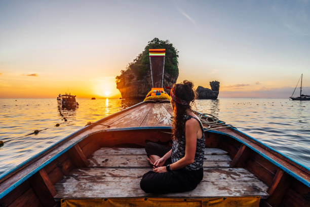 istock Young woman on a longtail boat in Thailand during sunset, Phi Phi Island 1197477000