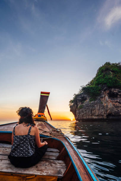 istock Young woman on a longtail boat in Thailand during sunset, Phi Phi Island 1197477011
