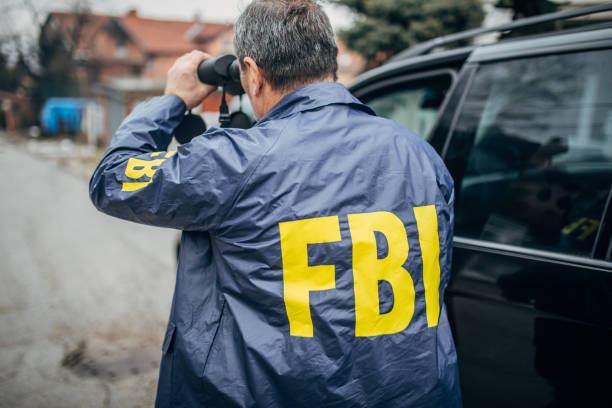 istock An FBI agent uses binoculars 1197477037