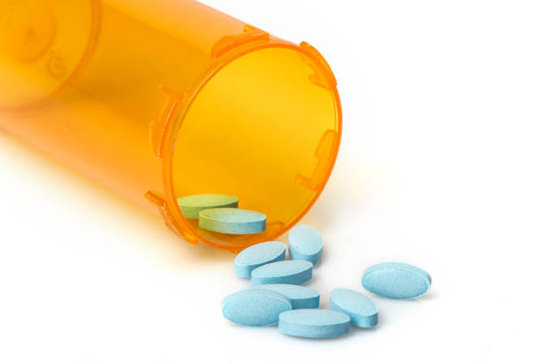 istock Blue Pills Spilling out of container 1197479100