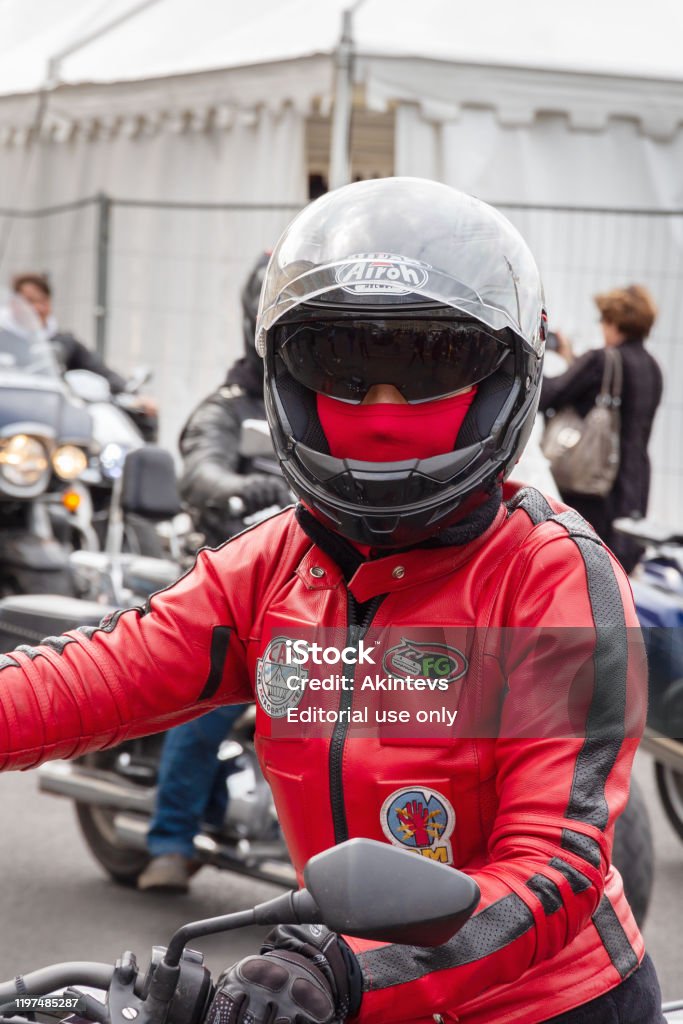 Mujer De Plano En Un Casco Moto Con Una Máscara De Cara Cerrada Una Chaqueta Roja Se Sienta En Una Motocicleta Foto de stock más banco de imágenes