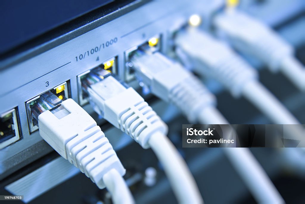 A row of cables attached to the back of a computer network cables RJ45 connected to a switch Close-up Stock Photo