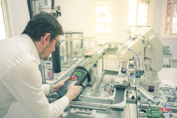 istock holding teach panel to control a robot arm which is integrated on smart factory production line 1197489583