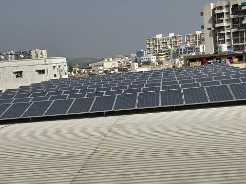 Solar panels on building roof with urban skyline