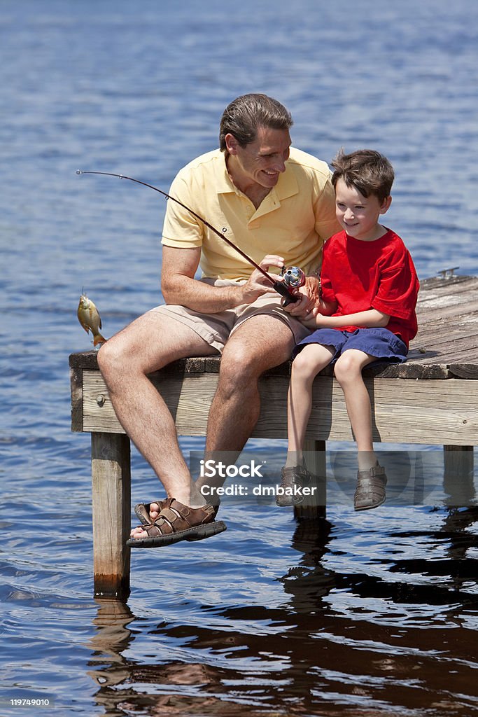 Père avec Son fils de pêche sur un ponton - Photo de Enseigner libre de droits