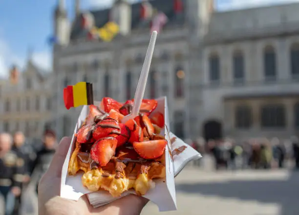 Traditional Belgian waffle dessert. Delicious cake with chocolate and fruits with flag.