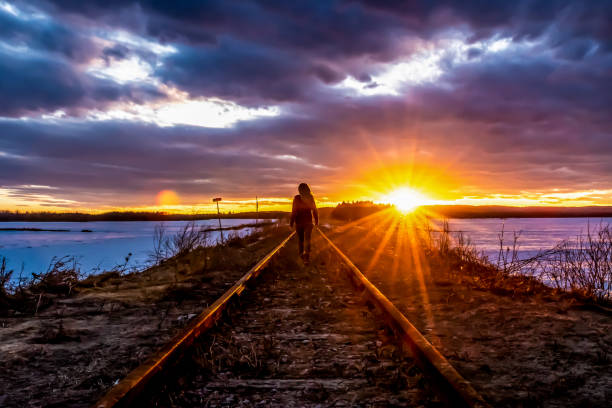 istock Woman on a railroad track at sunset. 1197491901
