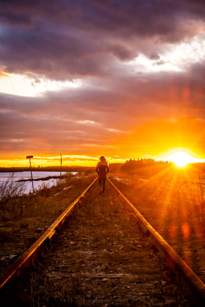 istock Woman on a railroad track at sunset. 1197491978