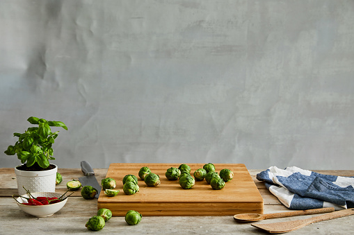 Brussels sprouts are placed on a wooden cutting board. Brussels sprouts are fresh from a local market. Brussels sprouts are homegrown.