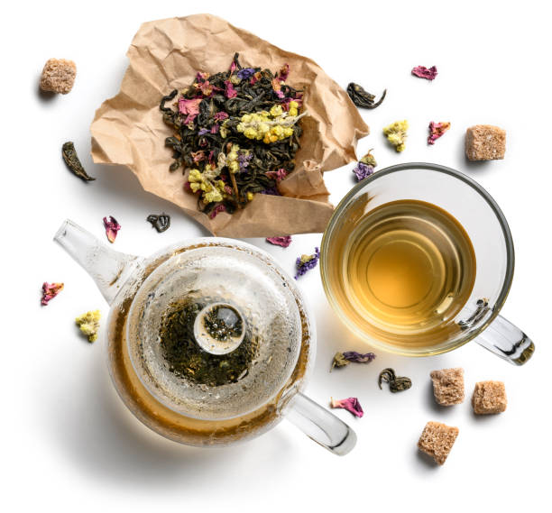 istock Green tea with natural aromatic additives, teapot and a cup. Top view on white background 1197497173