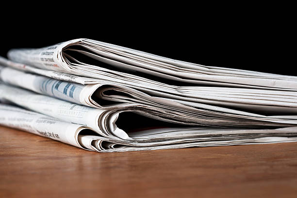istock Stack of newspapers on a wooden surface 119749935