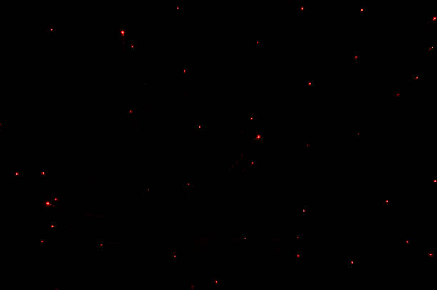 красные светящиеся огни точек от фейерверков в ночном черном небе - party time flash стоковые фото и изображения