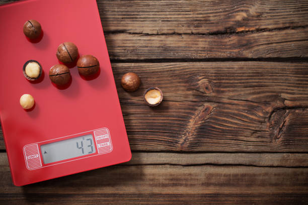 istock macadamia nuts on red kitchen scales on wooden background 1197505365