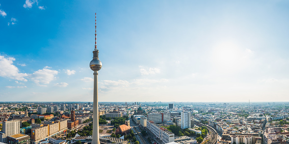 Summer sunlight flaring over the rooftops of central Berlin overlooked by the iconic spire of Fernsehturm, Alexanderplatz, in the heart of Berlin, Germany’s vibrant capital city.