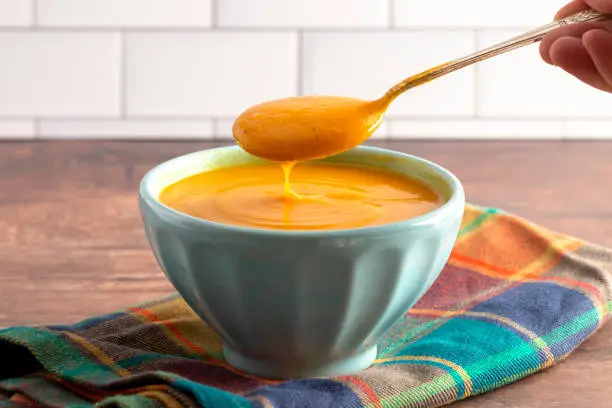 Healthy Sweet Potato and Sage Soup on a Rustic Wooden Table
