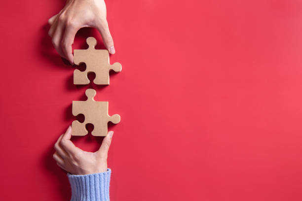 Two hands holding jigsaw, Concept for teamwork Building a success.