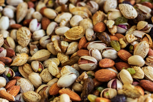 istock Mix of different delicious nuts and raisins background. 1197509579