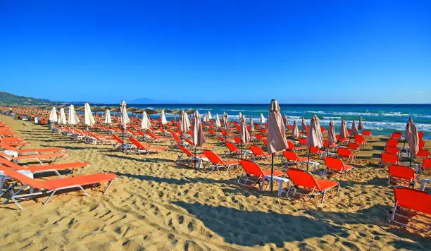 Photo of Umbrellas and sundecks of the sandy Banana Beach on Zakynthos, Greece.