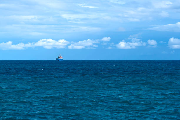 istock Blue sea, cloudy sky and ship on horizon 1197512081