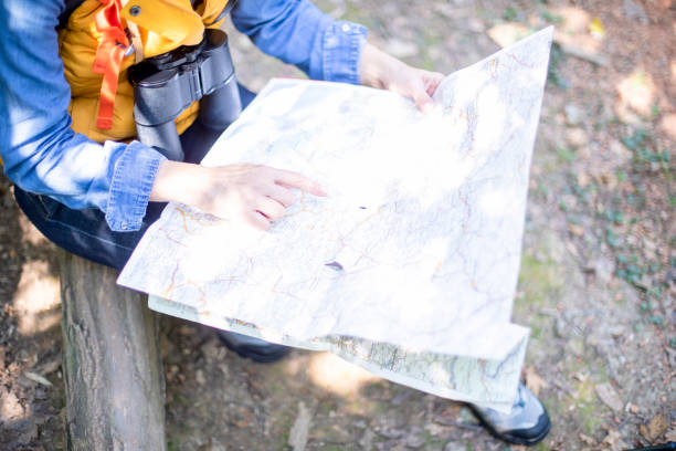istock Unknown senior woman hiking in forest with topographic map. 1197513151