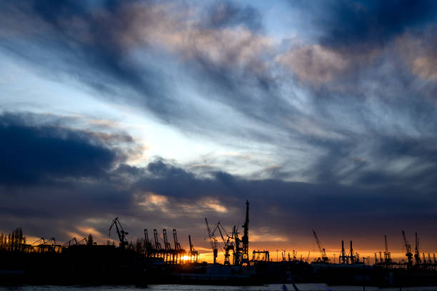 istock as Silhouette visible the crane's of the container harbor  with a dramatic sunset sky 1197514176