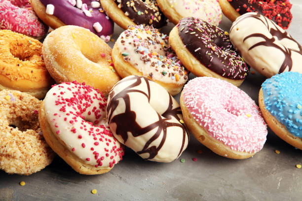 istock assorted donuts with chocolate frosted, pink glazed and sprinkles donuts 1197517526