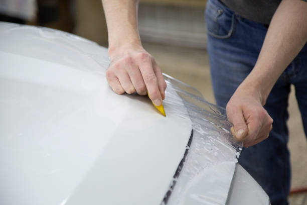 istock Installing a protective film on the car body 1197519539