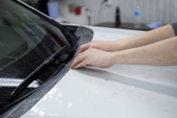 istock Installing a protective film on the car body 1197519559