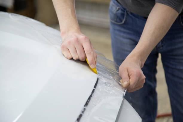 istock Installing a protective film on the car body 1197519571
